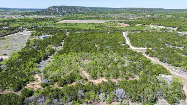 an aerial view of residential houses with outdoor space and trees