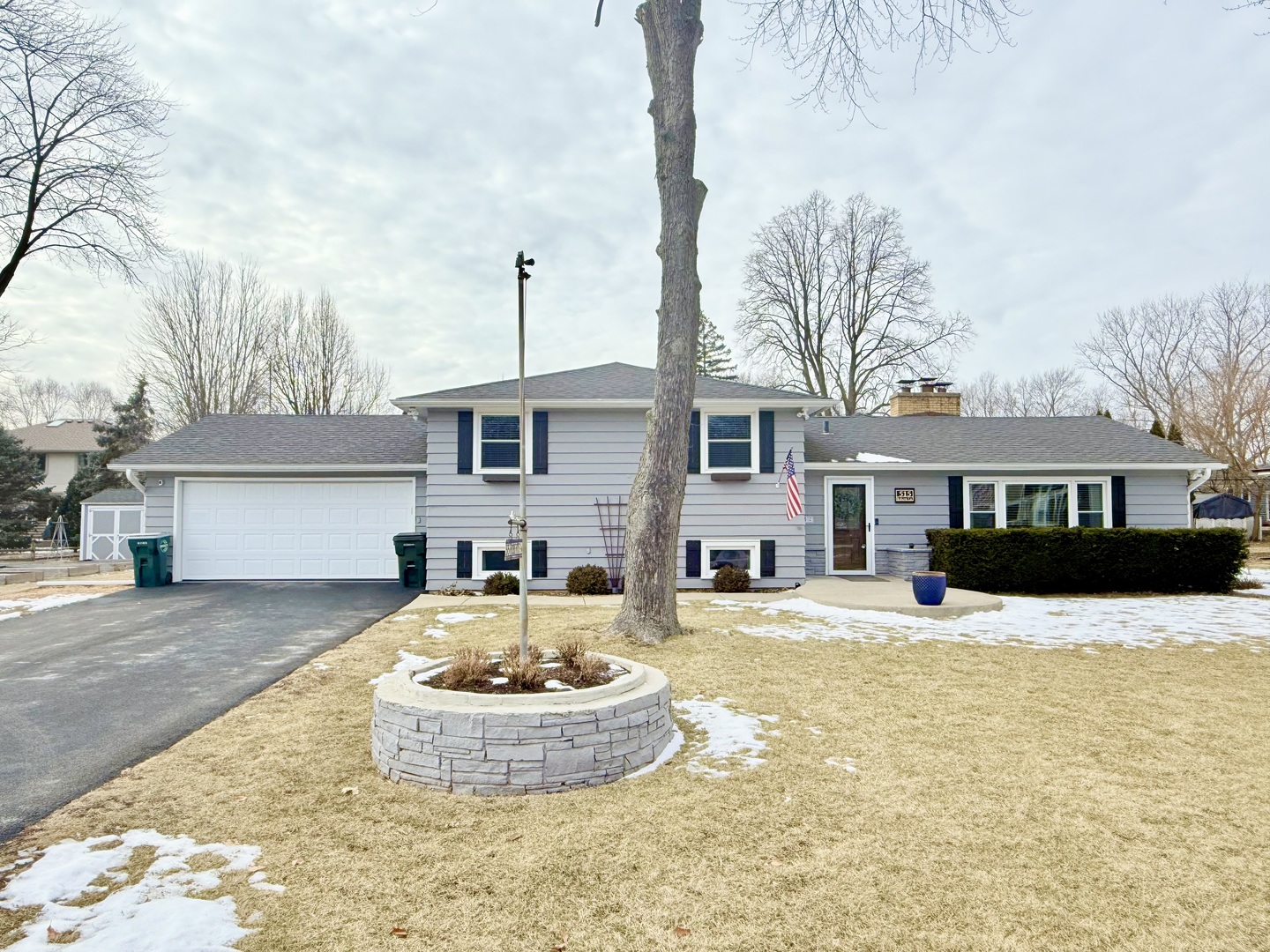 a front view of a house with a yard and trees