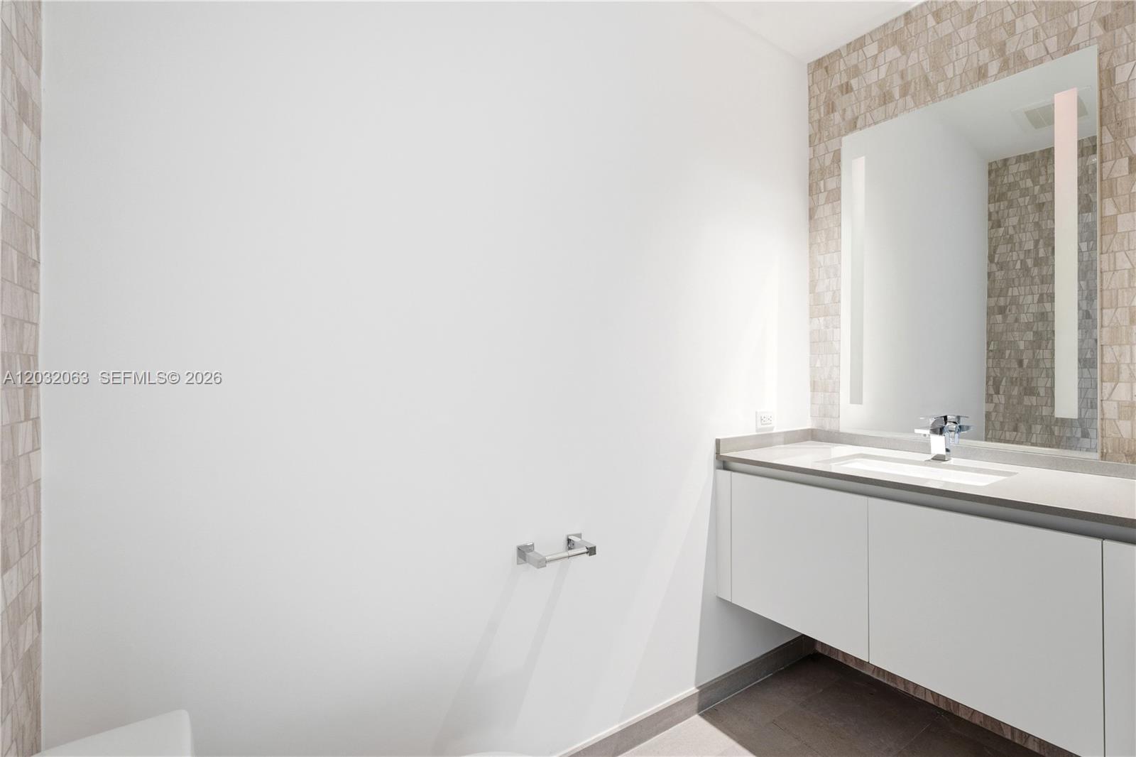 88 Southwest 7th Street, Unit 2302 Miami, FL 33130 - Photo 18 of 26 a bathroom with a sink and a mirror