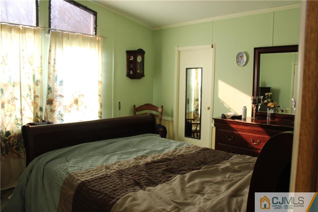 5 Poe Road North Brunswick, NJ 08902 - Photo 7 of 10 a bedroom with a bed and a dresser with mirror