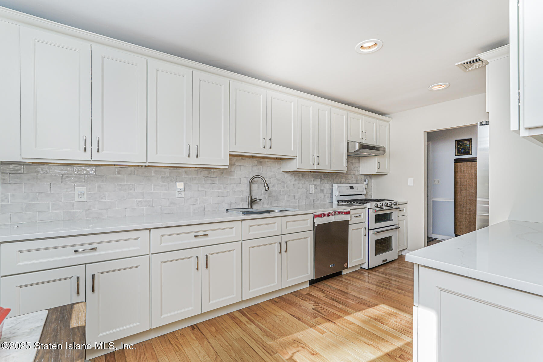 20 Signal Hill Road Staten Island, NY 10301 - Photo 9 of 42 a kitchen with granite countertop white cabinets and white appliances