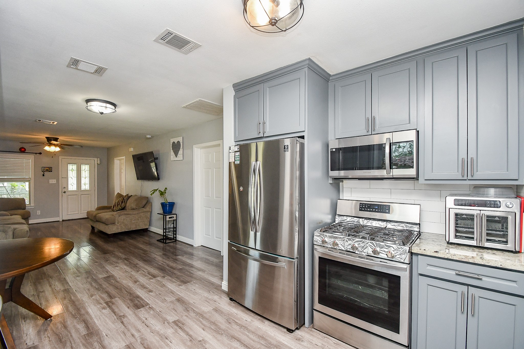 1607 Sylvester Road Houston, TX 77009 - Photo 11 of 32 a kitchen with stainless steel appliances a stove a microwave and a refrigerator