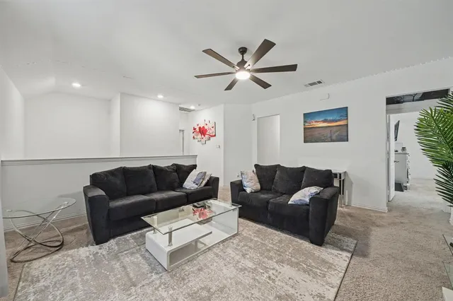 a living room with furniture and a ceiling fan