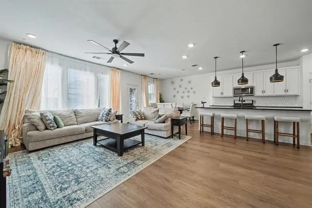 a living room with lots of furniture and kitchen view