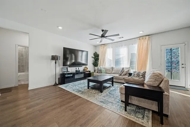 a living room with furniture and a wooden floor