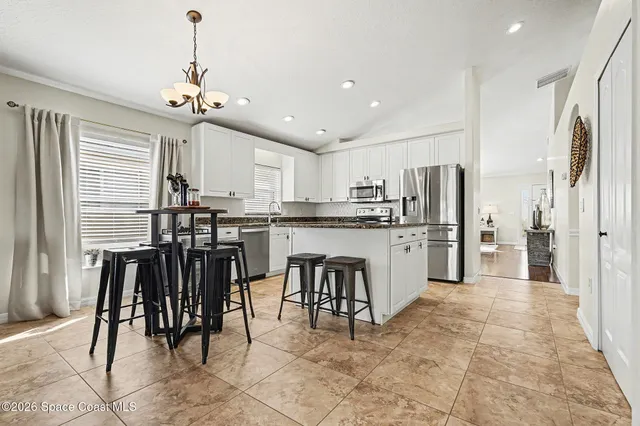 a kitchen with cabinets and chairs