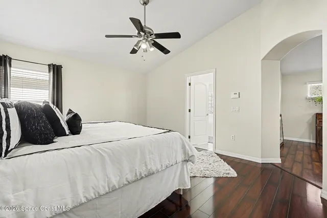 a bedroom with a bed and wooden floor