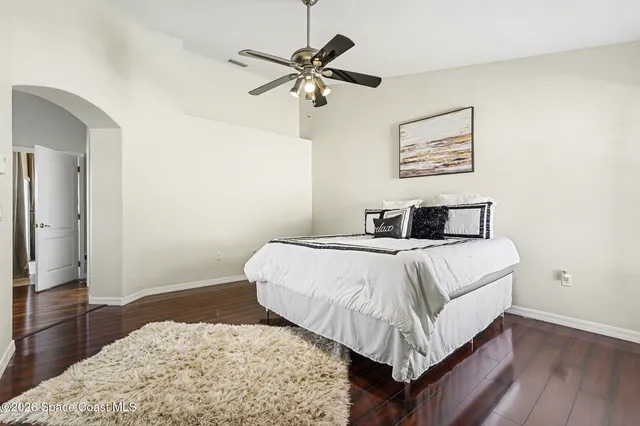 a bedroom with a bed and wooden floor