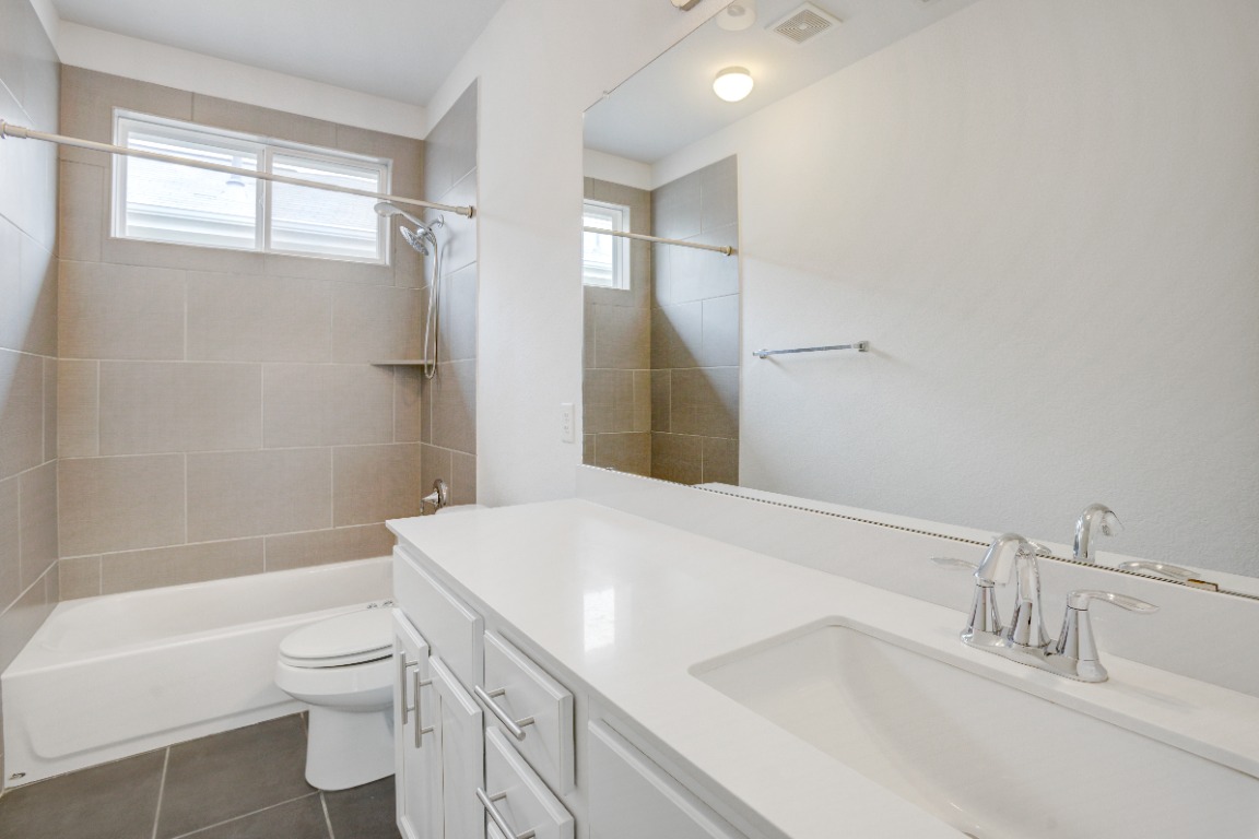 5910 Rubicon Run Austin, TX 78745 - Photo 17 of 18 Full bathroom with vanity, shower / bath combination, and dark tile patterned flooring