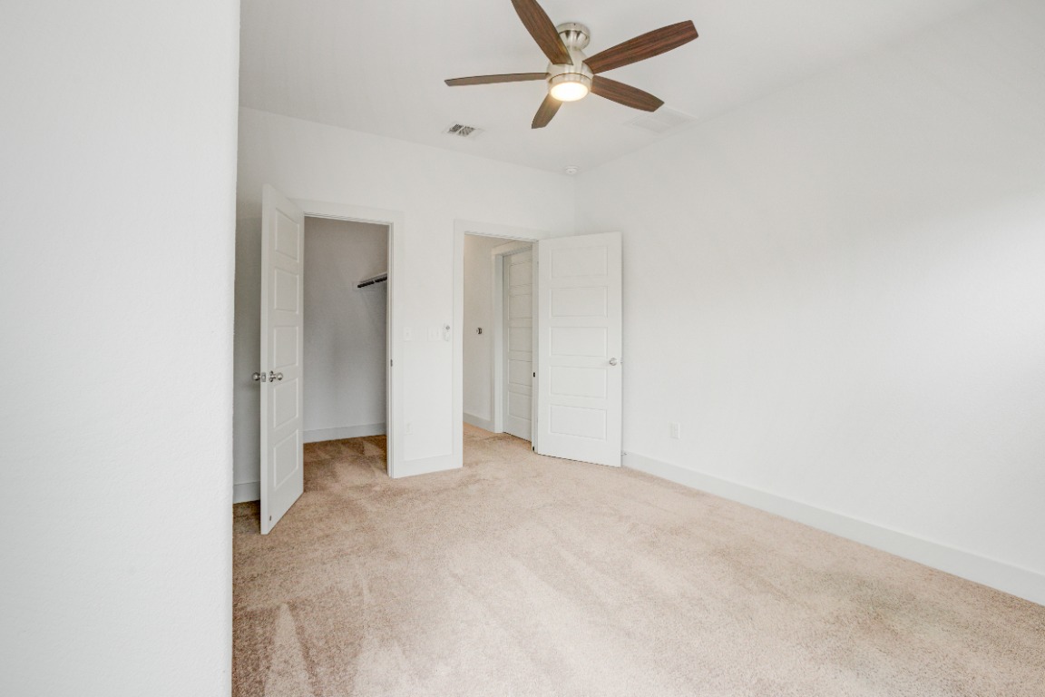 5910 Rubicon Run Austin, TX 78745 - Photo 6 of 18 Unfurnished bedroom featuring a spacious closet, light carpet, and a ceiling fan