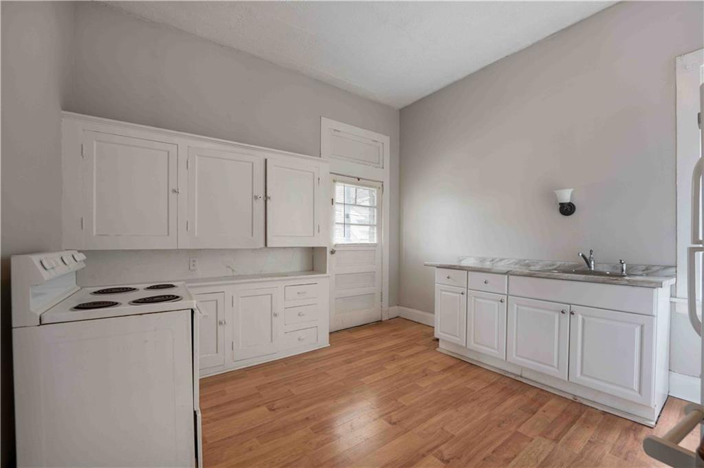 254-256 Pennsylvania Avenue Rochester, PA 15074 - Photo 16 of 32 a kitchen with granite countertop white cabinets and white appliances