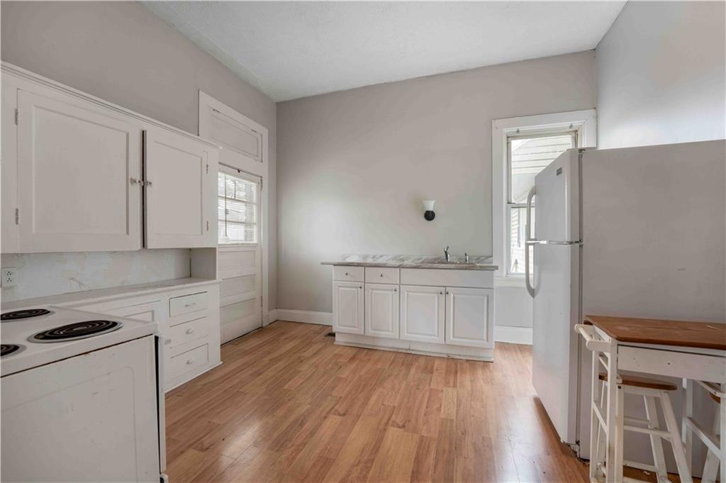 254-256 Pennsylvania Avenue Rochester, PA 15074 - Photo 17 of 32 a kitchen with white cabinets and wooden floor