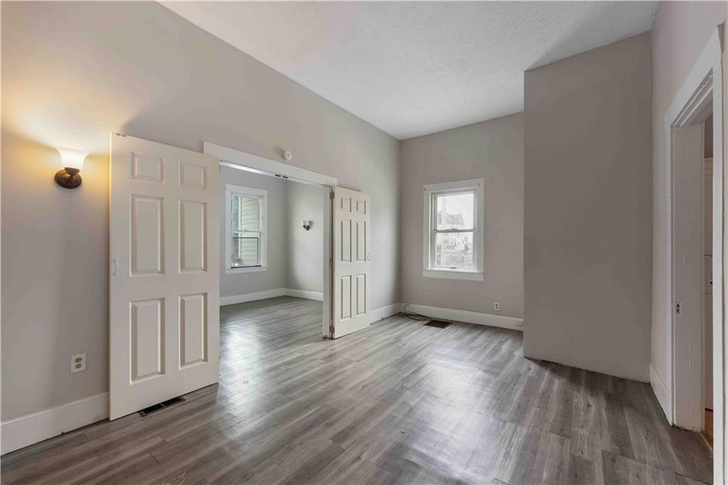 254-256 Pennsylvania Avenue Rochester, PA 15074 - Photo 23 of 32 a view of an empty room with wooden floor and a window