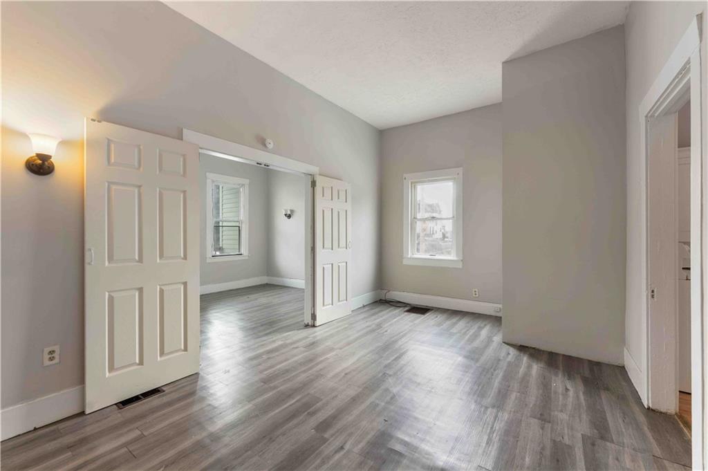 254-256 Pennsylvania Avenue Rochester, PA 15074 - Photo 25 of 32 a view of an empty room with wooden floor and a window