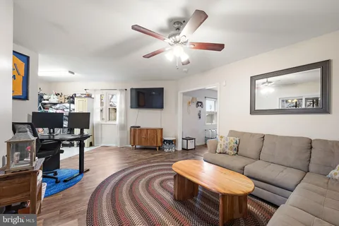 a living room with furniture and a flat screen tv with wooden floor