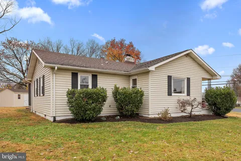 a front view of house with yard and trees in the background