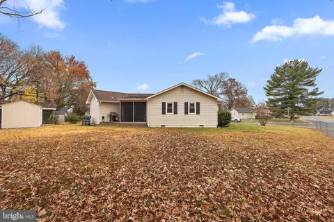 a view of house with backyard and trees