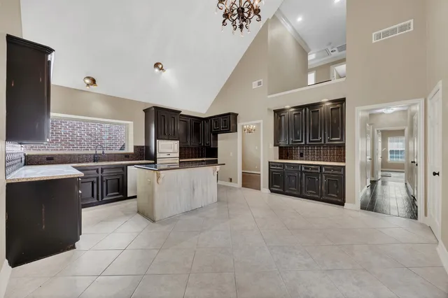 a large kitchen with stainless steel appliances a stove a sink and a refrigerator