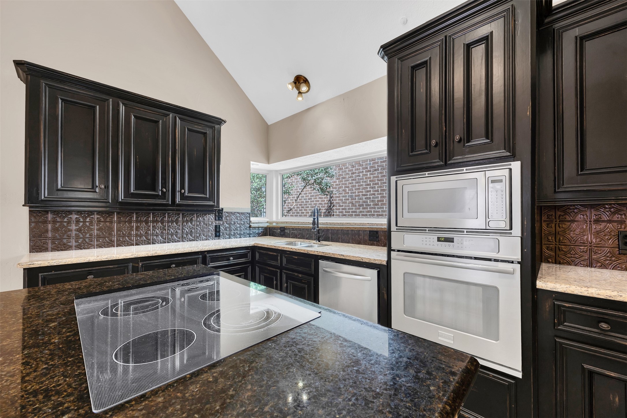 7659 Ameswood Road Houston, TX 77095 - Photo 6 of 24 a kitchen with stainless steel appliances granite countertop a sink stove and microwave