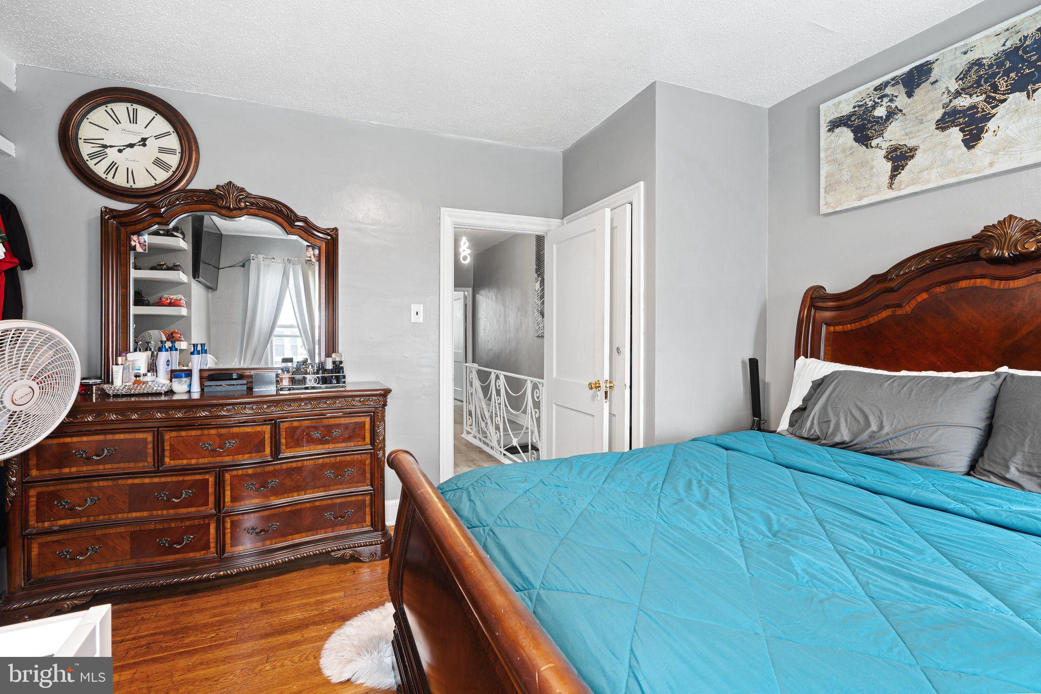5431 Akron Street Philadelphia, PA 19124 - Photo 17 of 32 a bedroom with a bed a clock on the wall and a table