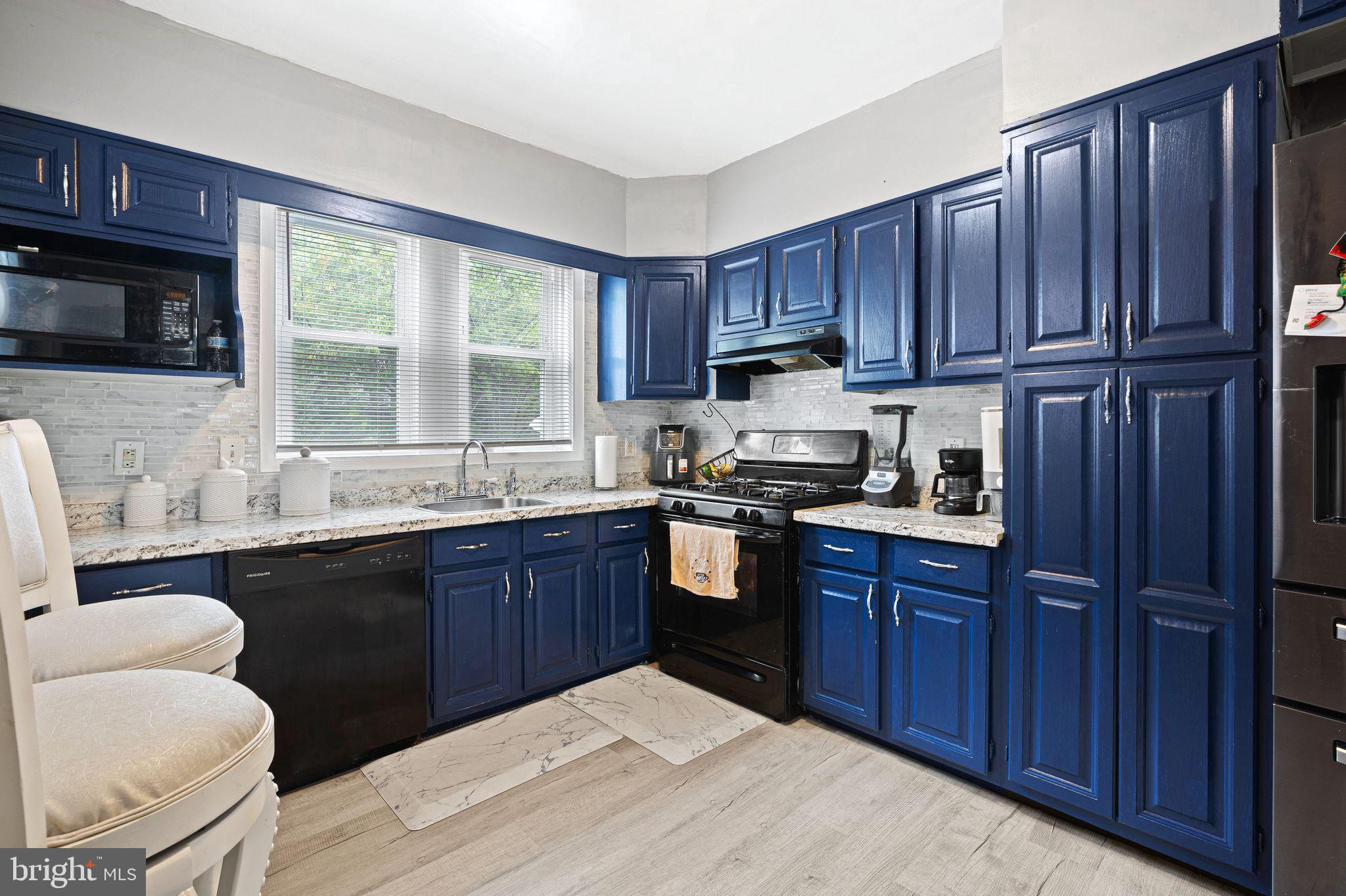 5431 Akron Street Philadelphia, PA 19124 - Photo 10 of 32 a kitchen with granite countertop wooden cabinets a stove a sink and a oven