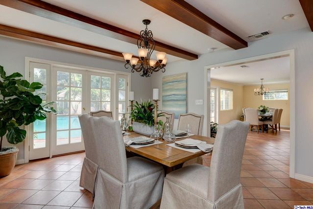 a living room with furniture a chandelier and a dining table