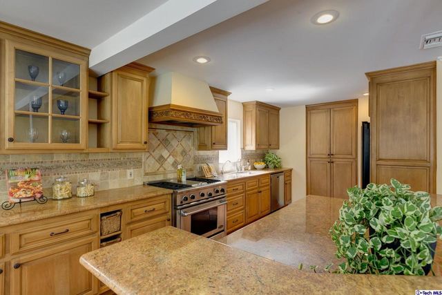 a kitchen with stainless steel appliances granite countertop a stove a sink and a refrigerator