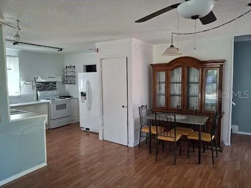 a kitchen with stainless steel appliances a table chairs refrigerator and cabinets