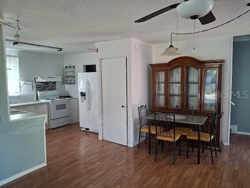 9723 Tom Street Hudson, FL 34669 - Photo 3 of 10 a kitchen with stainless steel appliances a table chairs refrigerator and cabinets