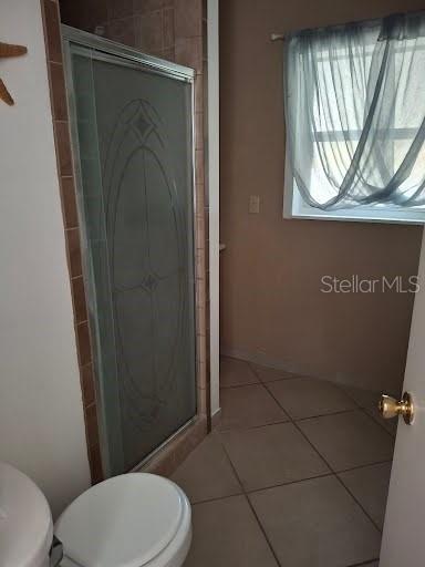 9723 Tom Street Hudson, FL 34669 - Photo 5 of 10 a bathroom with a toilet and a shower curtain