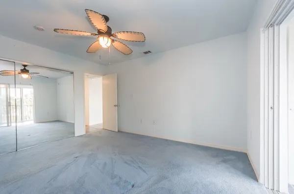 an empty room with closet and windows