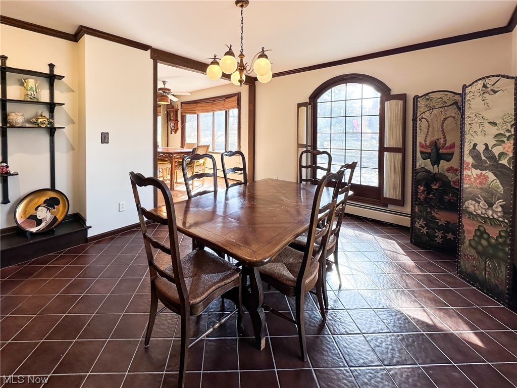 11911 County Line Road Chesterland, OH 44026 - Photo 9 of 49 Tiled dining room featuring ceiling fan with notable chandelier, baseboard heating, ornamental molding, and a wealth of natural light