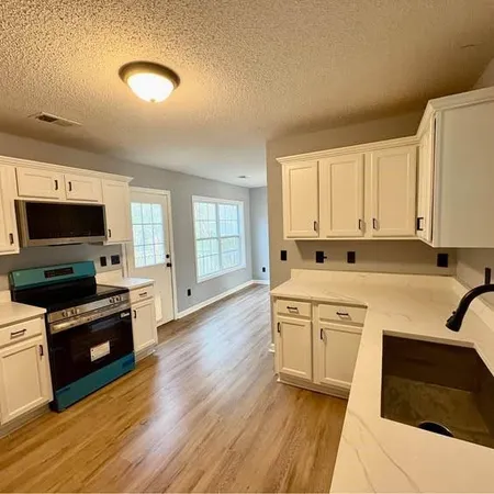a kitchen with granite countertop white cabinets and white appliances