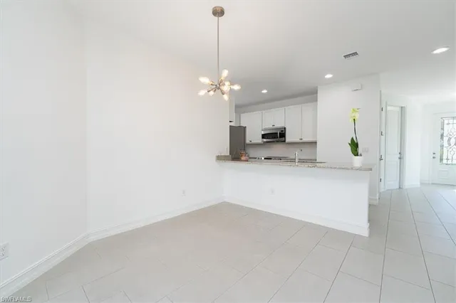 a living room with furniture a chandelier and a dining table