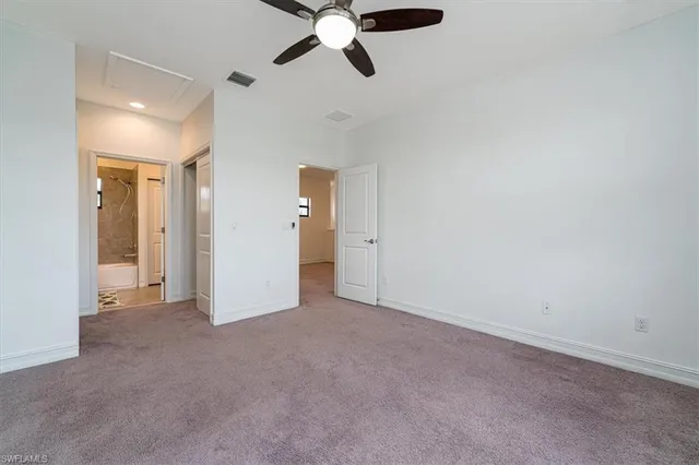 an empty room with closet and windows