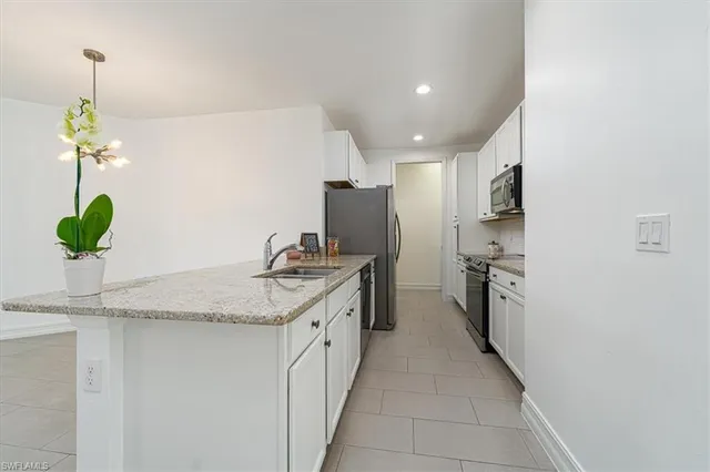 a kitchen with stainless steel appliances granite countertop a sink and a refrigerator