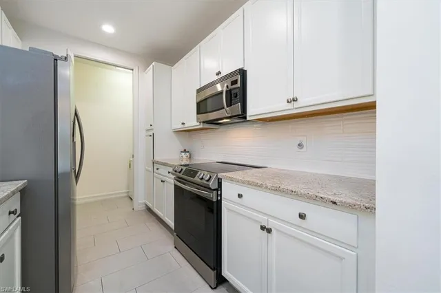 a kitchen with stainless steel appliances granite countertop a sink a stove and a refrigerator