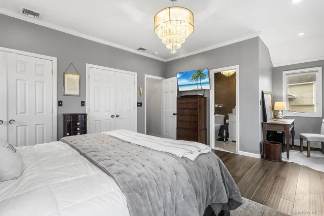 a spacious bedroom with a bed and a chandelier