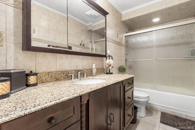 a bathroom with a granite countertop sink a toilet and bathtub