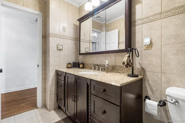a bathroom with a sink vanity granite and toilet