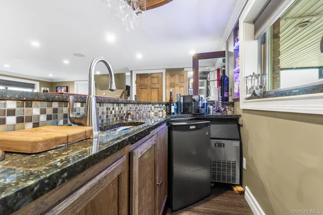 a kitchen with granite countertop a sink and cabinets