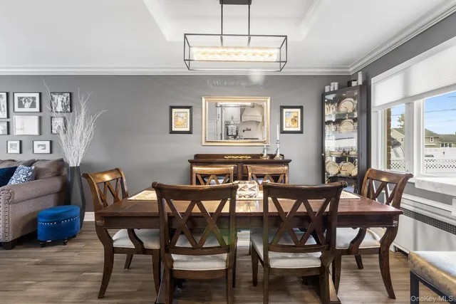 a view of a dining room with furniture a chandelier and wooden floor