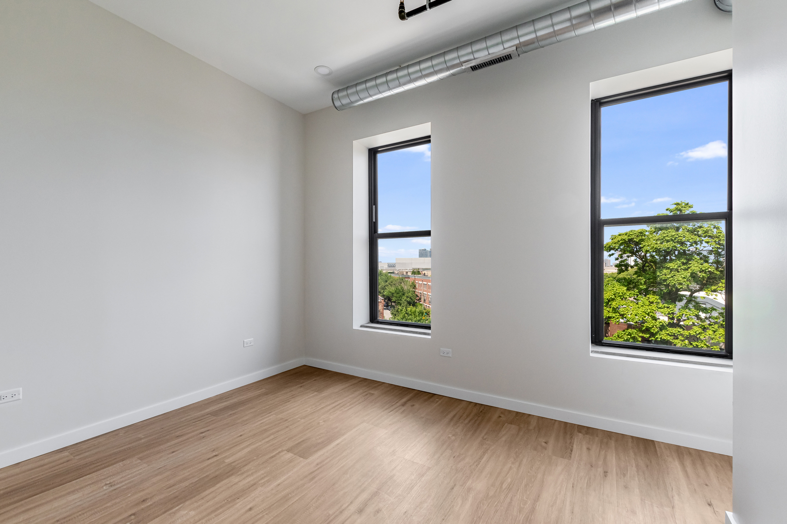 805 North Milwaukee Avenue, Unit 4N Chicago, IL 60642 - Photo 16 of 34 an empty room with wooden floor and windows