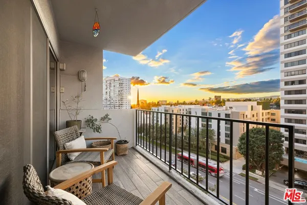 a balcony with wooden floor and outdoor seating