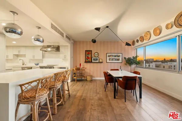a dining hall with stainless steel appliances granite countertop a stove and a view of living room