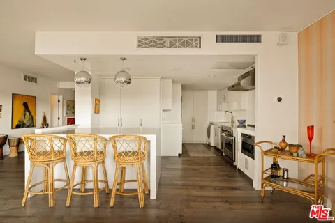 a large white kitchen with a table and chairs