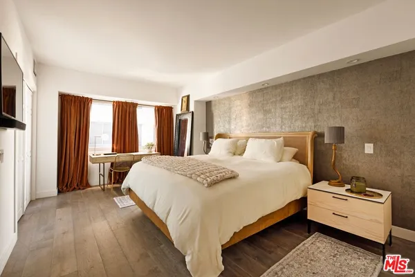 a bedroom with a bed and a large window