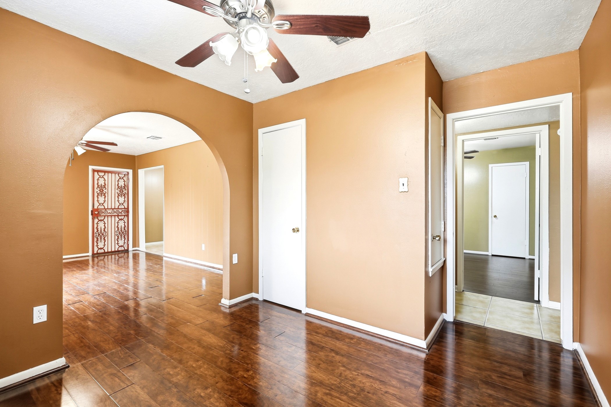 1507 Willow Rock Road Houston, TX 77088 - Photo 17 of 27 Dining room with an arched entry to the living area, laminate flooring, and a ceiling fan, a natural gathering space for meals and entertaining.