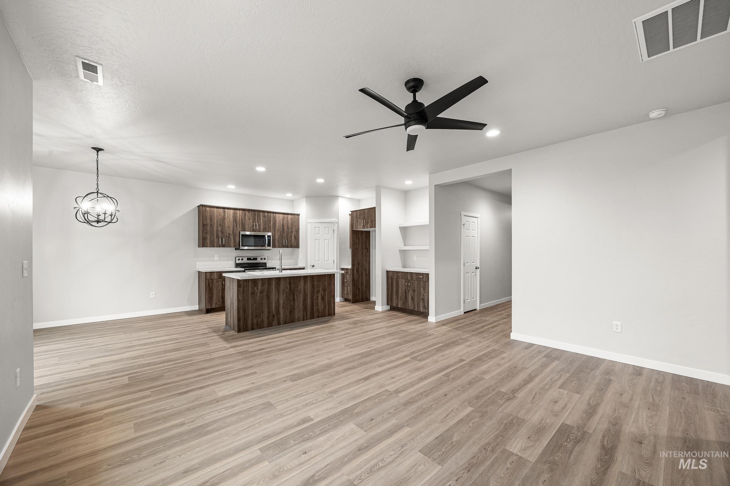 13656 Redway Court Caldwell, ID 83607 - Photo 10 of 21 Open-concept kitchen and dining area featuring wood-finish flooring, recessed lighting, and a contemporary chandelier