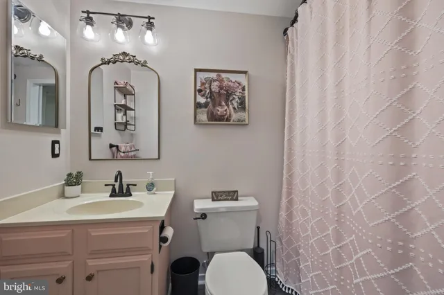 a bathroom with a granite countertop sink mirror and toilet